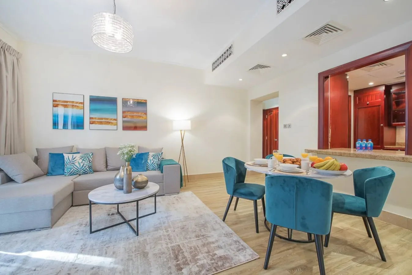 A bright living and dining area with a sectional seating arrangement and a table.