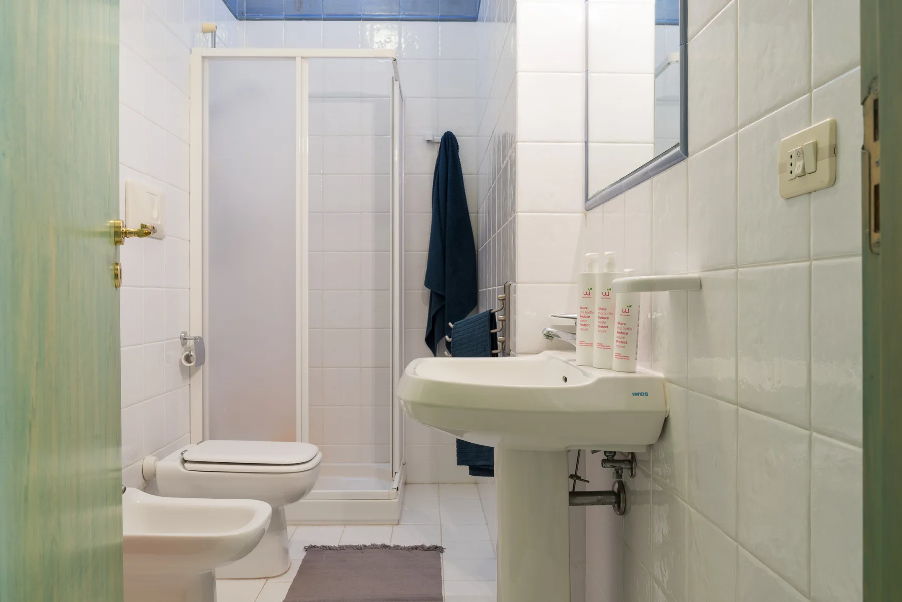 A tiled bathroom with a sink, toilet, and shower.