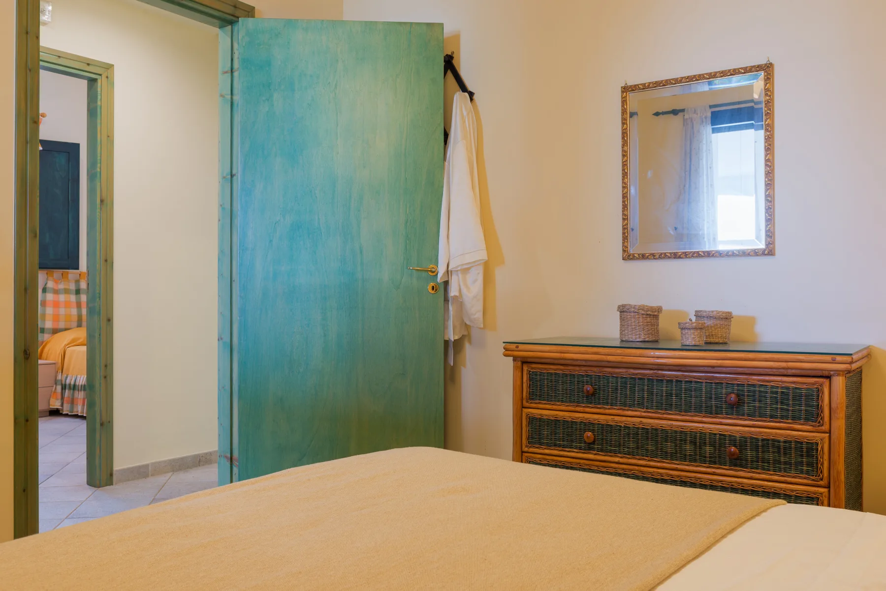 A bedroom with a bed, a dresser, and an open doorway.
