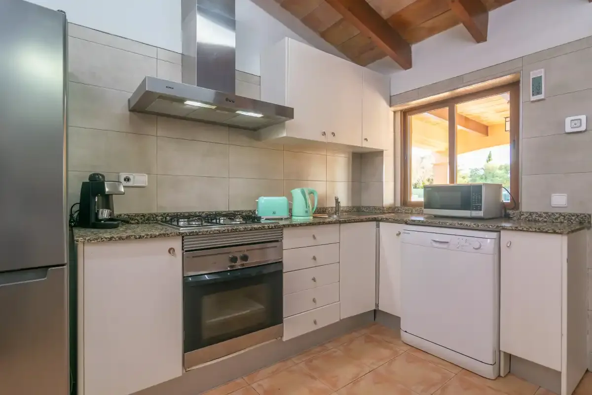 A fitted kitchen with a stovetop, oven, and countertop appliances.