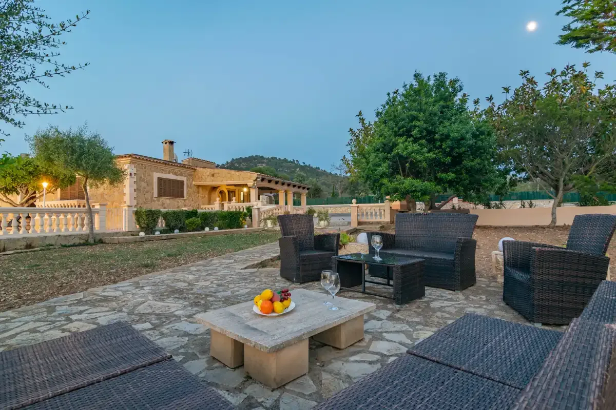 A stone-paved outdoor patio with dark woven seating and a low table.