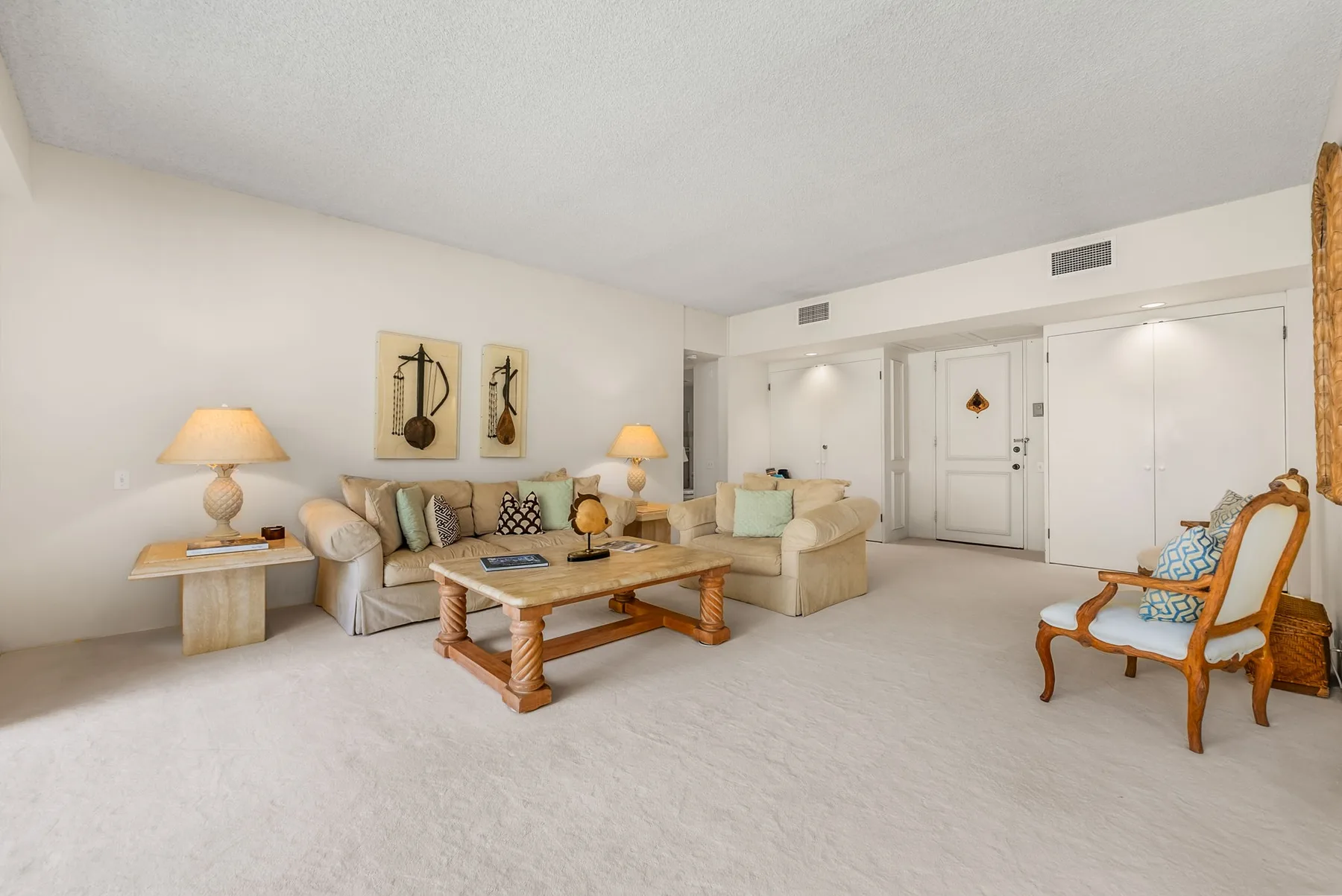 A bright living room with seating arranged around a wooden coffee table.