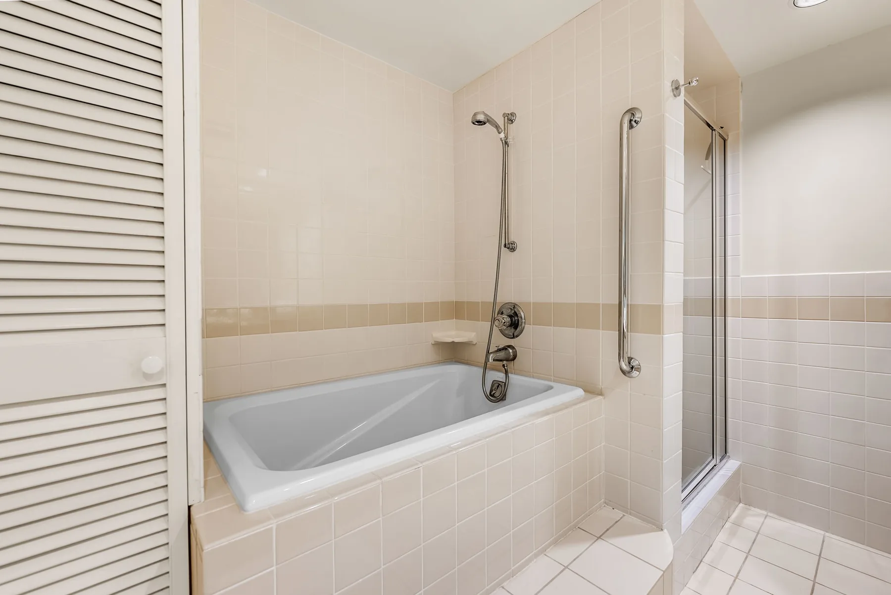 A tiled bathroom with a bathtub and shower.