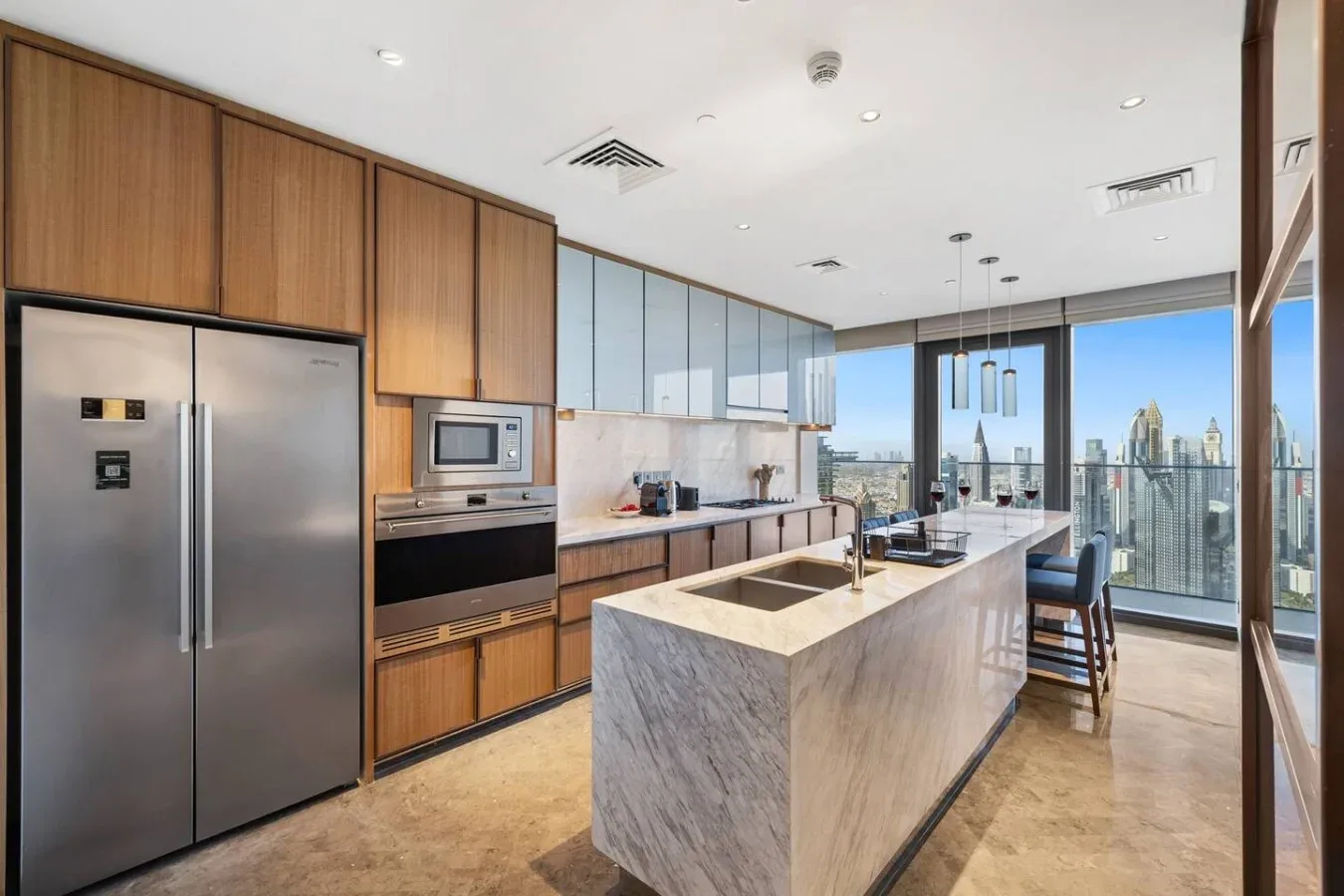 Una cocina moderna con gabinetes de madera, una isla amplia y ventanales de piso a techo.