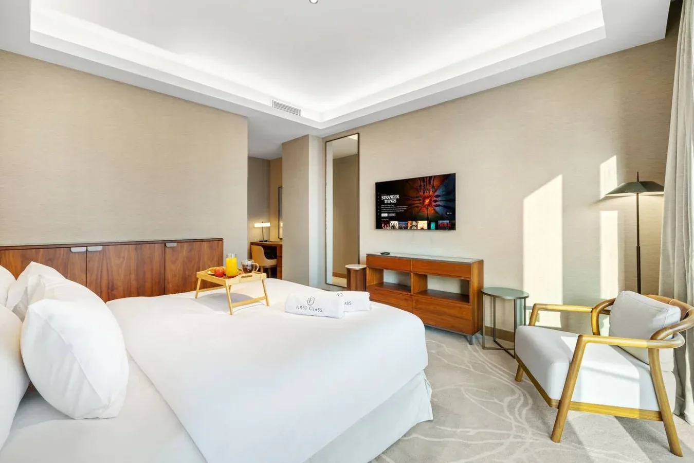 Un dormitorio con una cama grande, muebles de madera y una zona para sentarse.