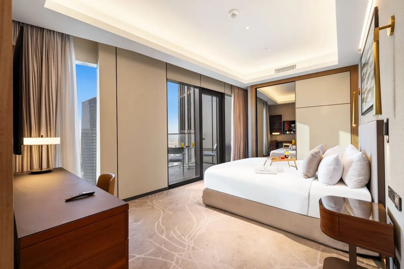 Un dormitorio con una cama grande, mesas de noche y ventanas de piso a techo.