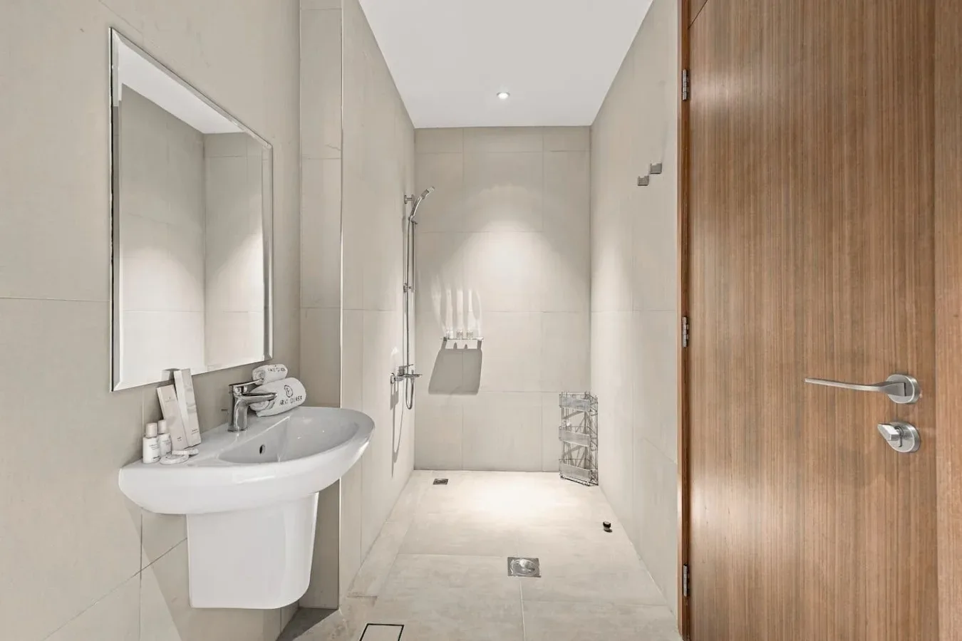 Un baño luminoso con azulejos, lavabo y ducha.