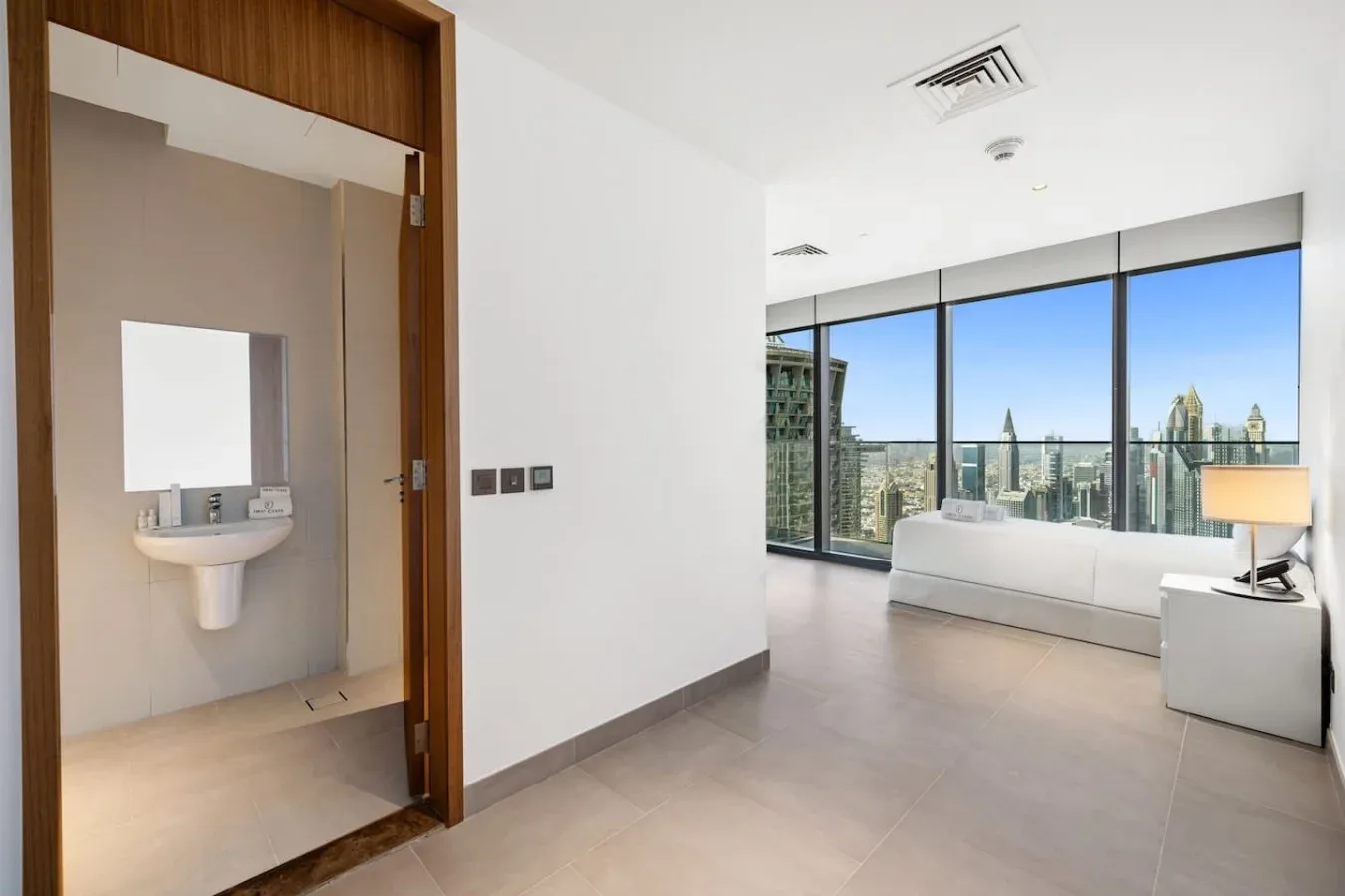 Una habitación luminosa y moderna con ventanales de piso a techo y vistas a la ciudad.