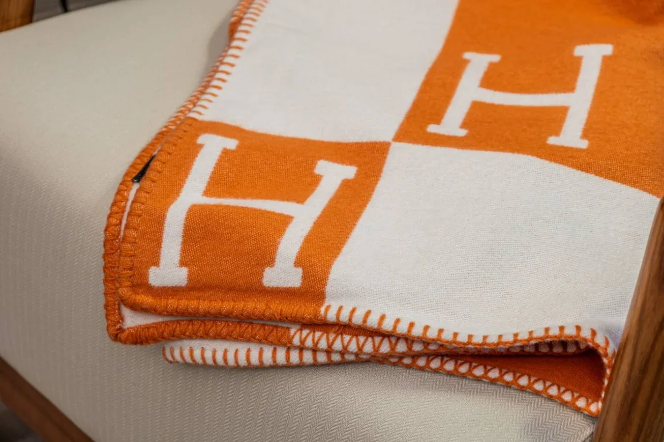 Primer plano de una manta estampada naranja y blanca sobre un asiento.