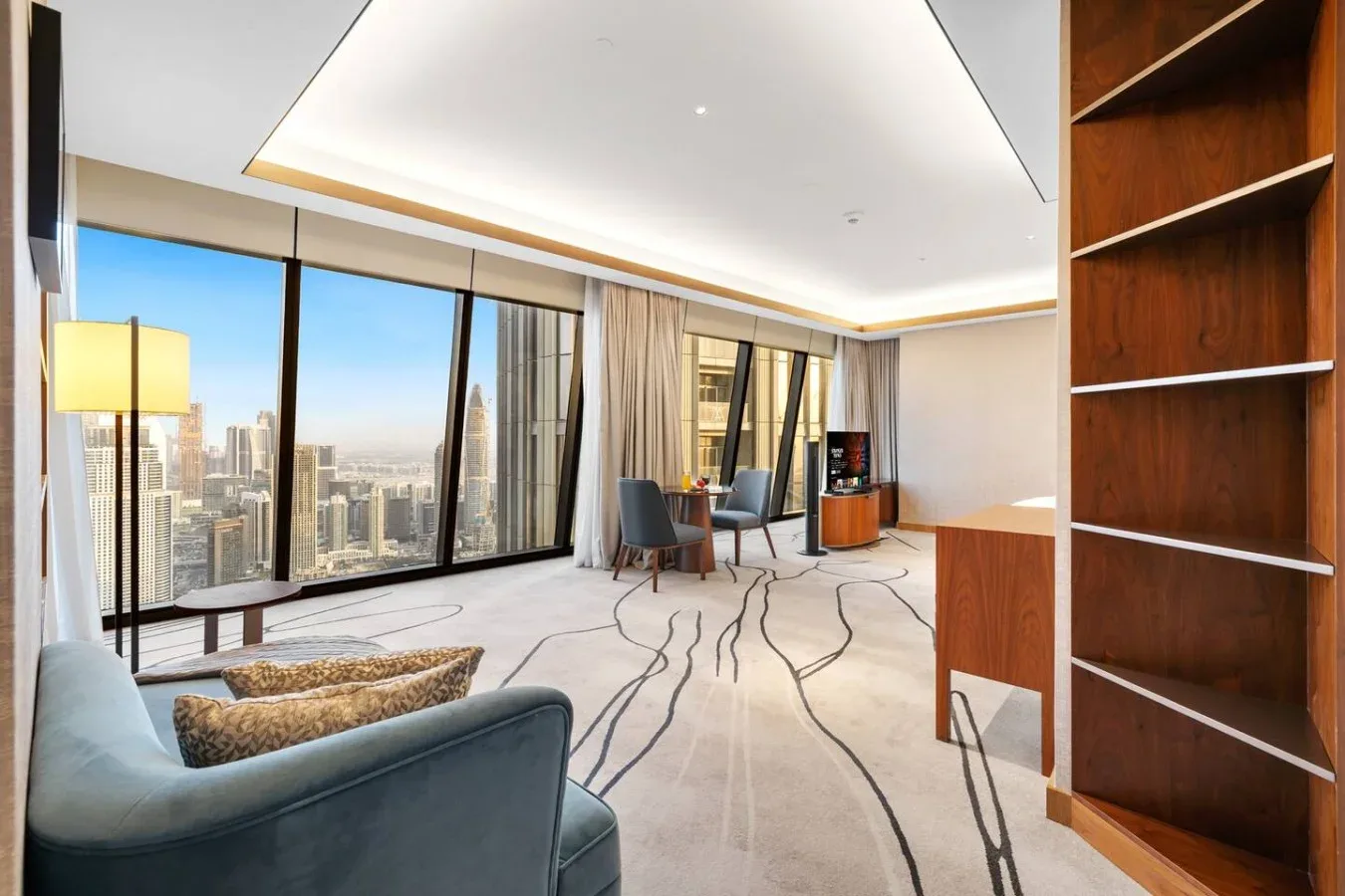 Una sala luminosa con ventanales de piso a techo con vistas a la ciudad.