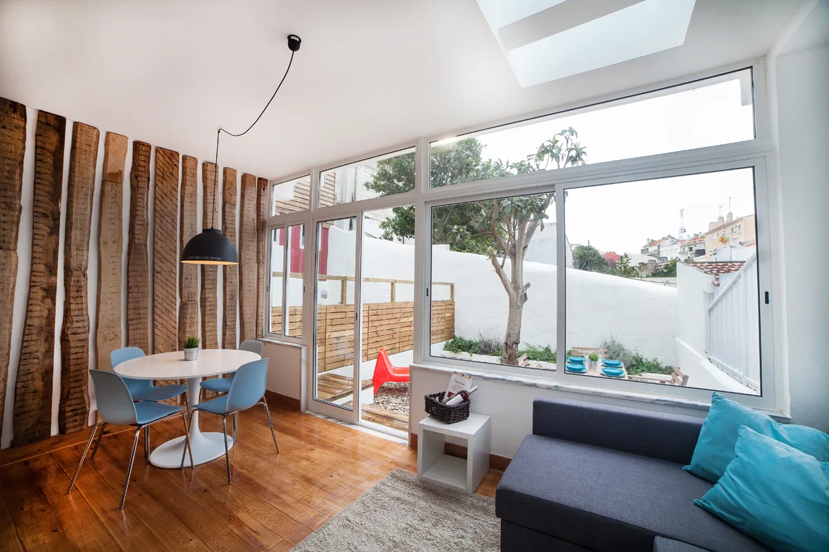 A bright living and dining area opens onto a small patio through large glass doors.