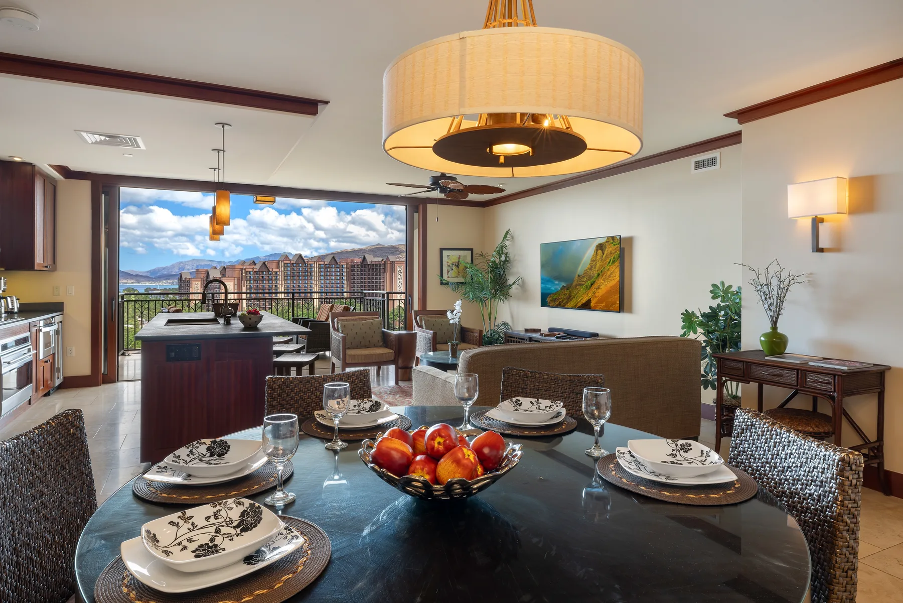 Comedor con la mesa puesta y una cocina abierta con vistas a un balcón.