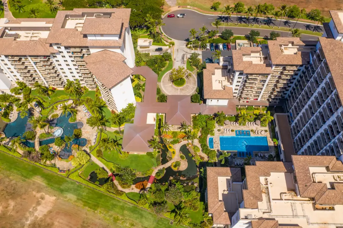 Vista aérea de un complejo turístico con jardines y una piscina.