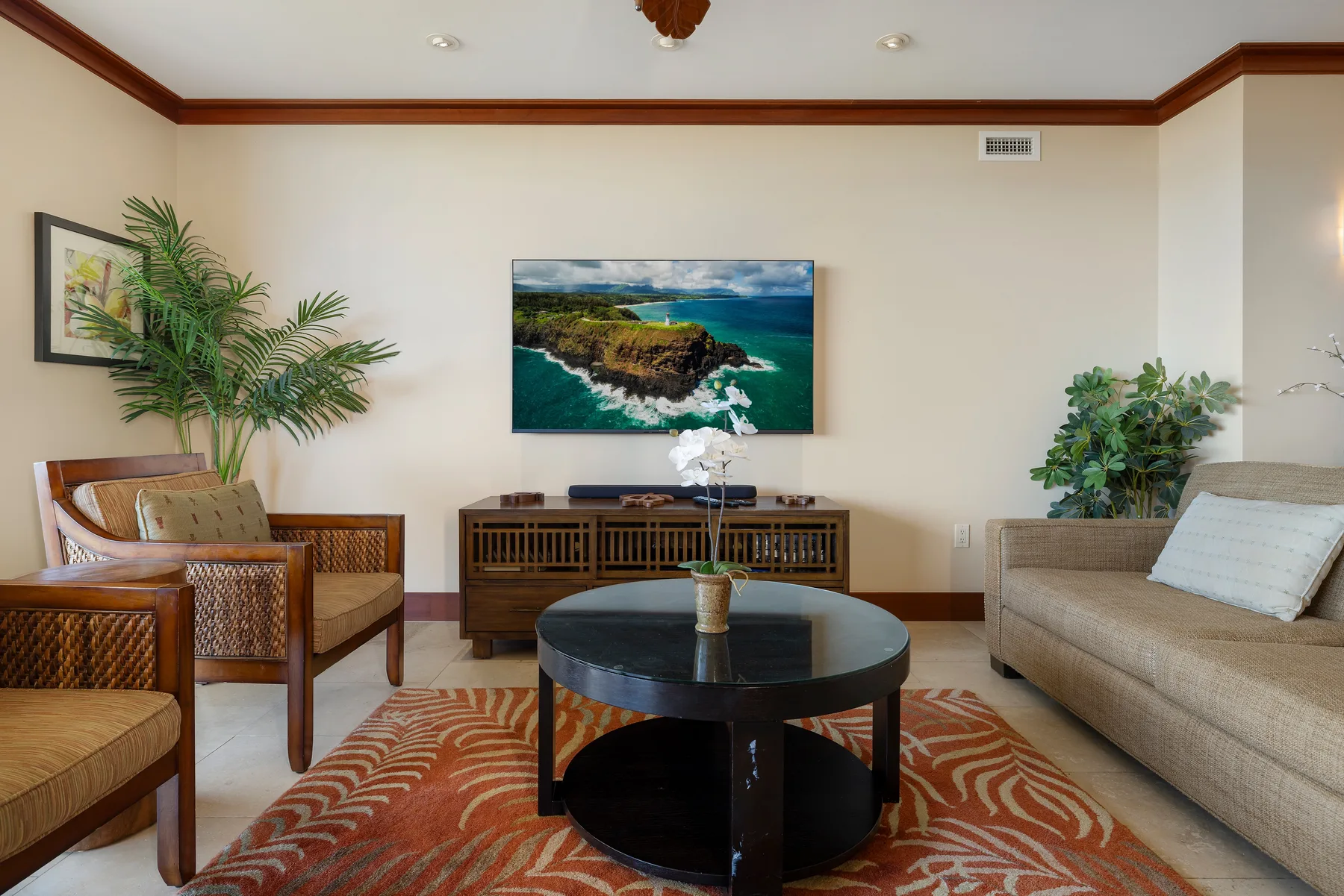 Una sala de estar con asientos dispuestos alrededor de una mesa de centro y un televisor.