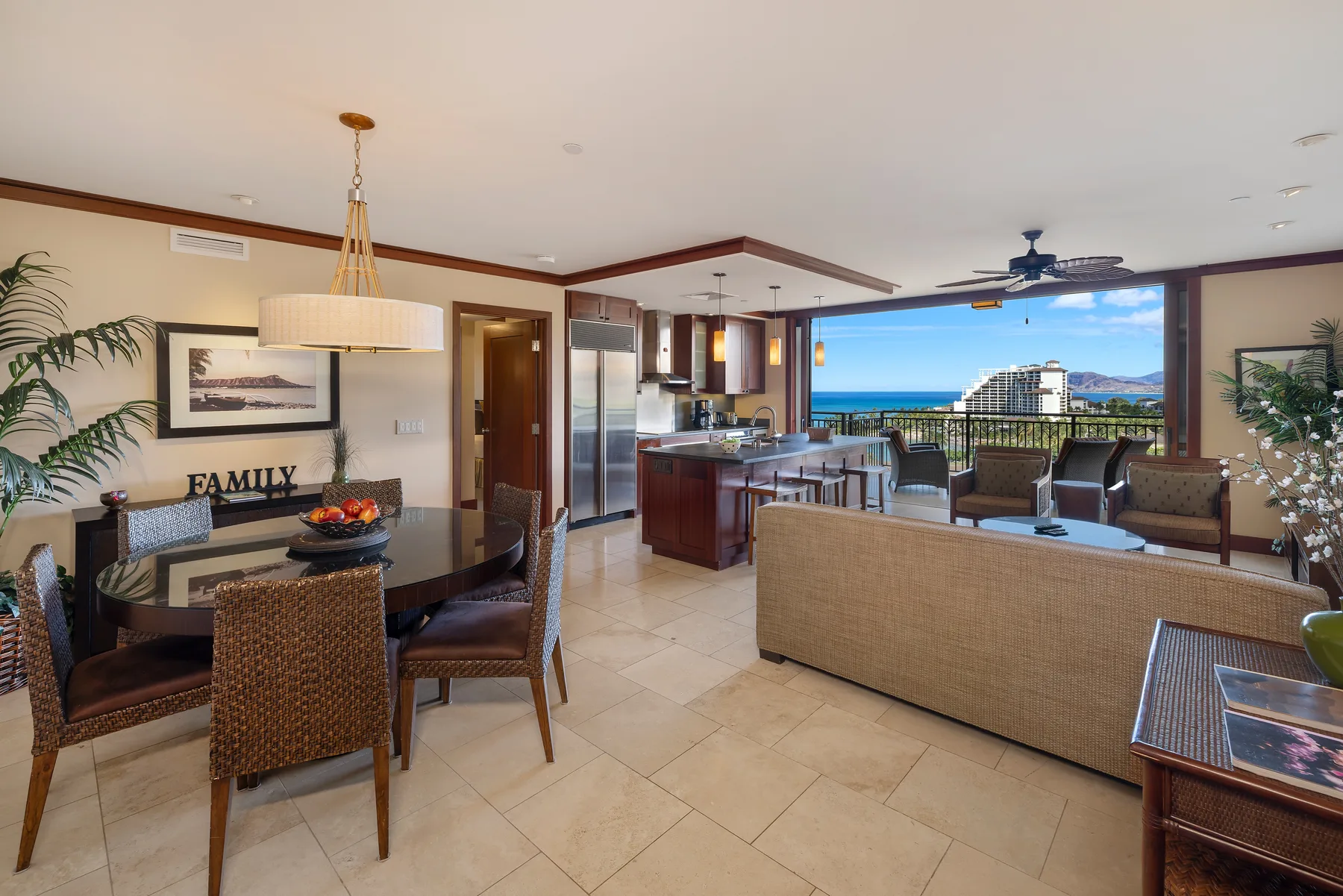 Una sala-comedor abierta con cocina y grandes ventanas con vistas al mar.