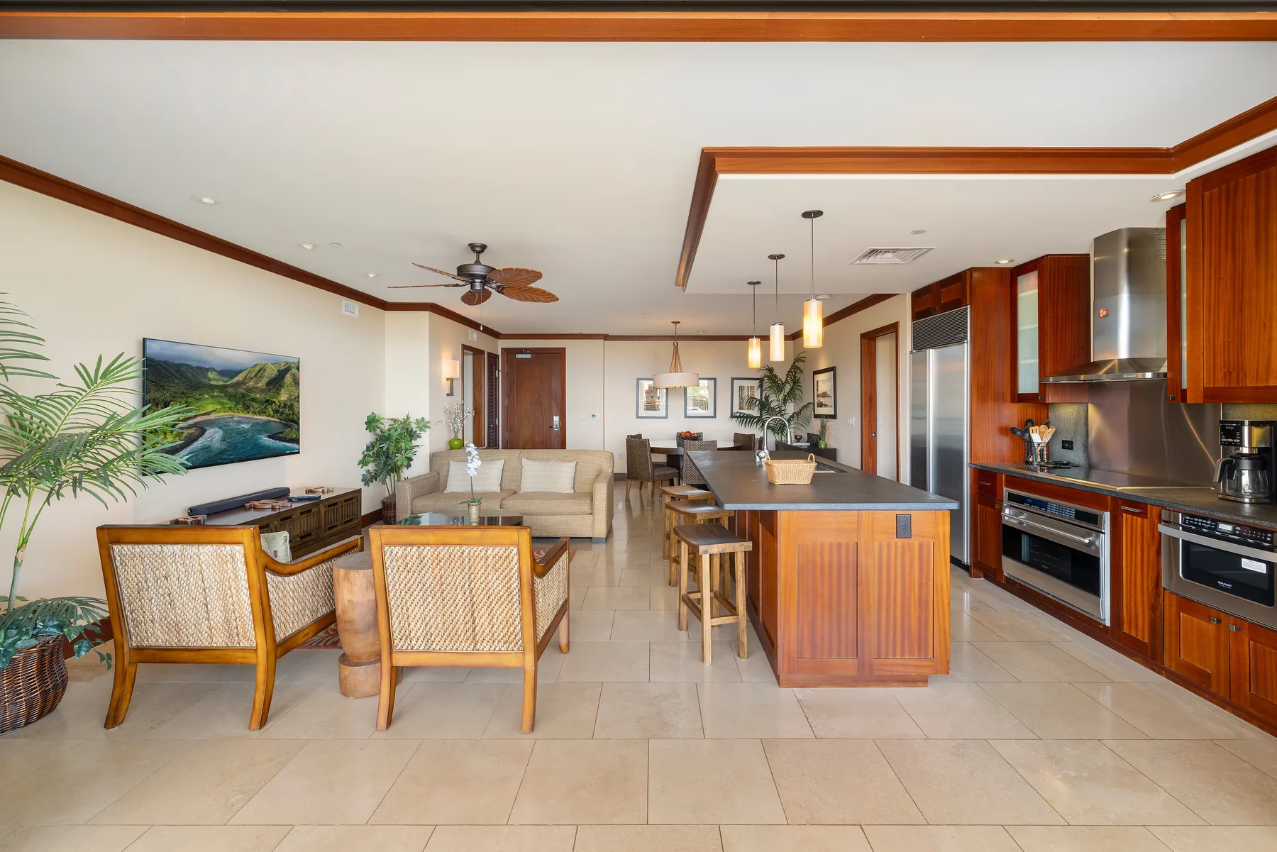 Una sala de estar y cocina de concepto abierto, con una isla central y asientos para comer.