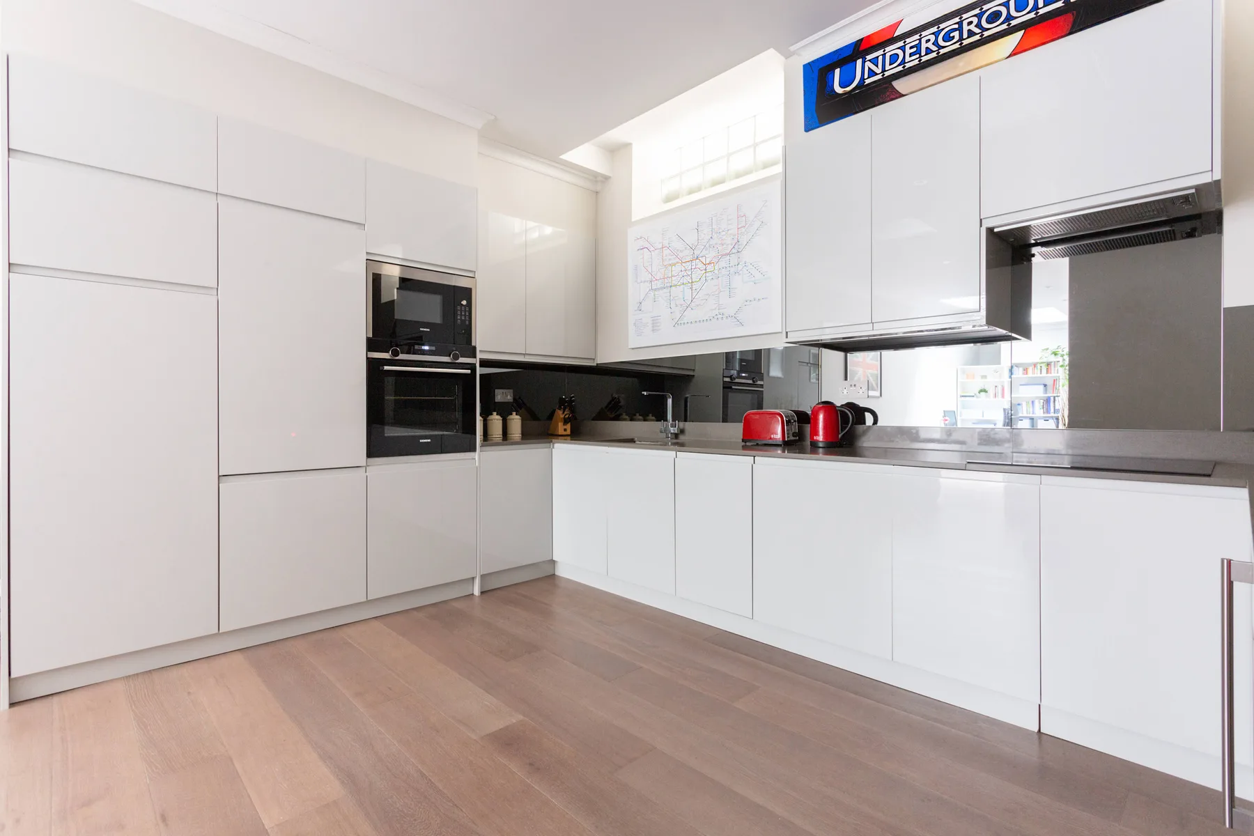 A bright modern kitchen with white cabinets and a countertop.