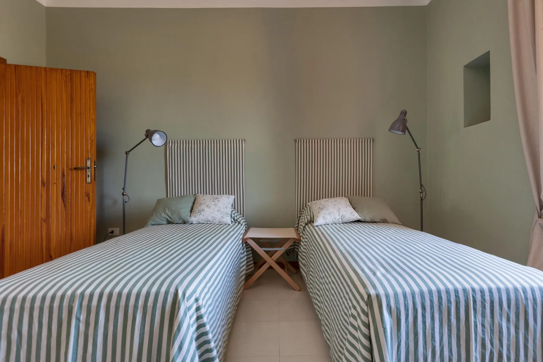 Un dormitorio con dos camas individuales junto a una mesita.