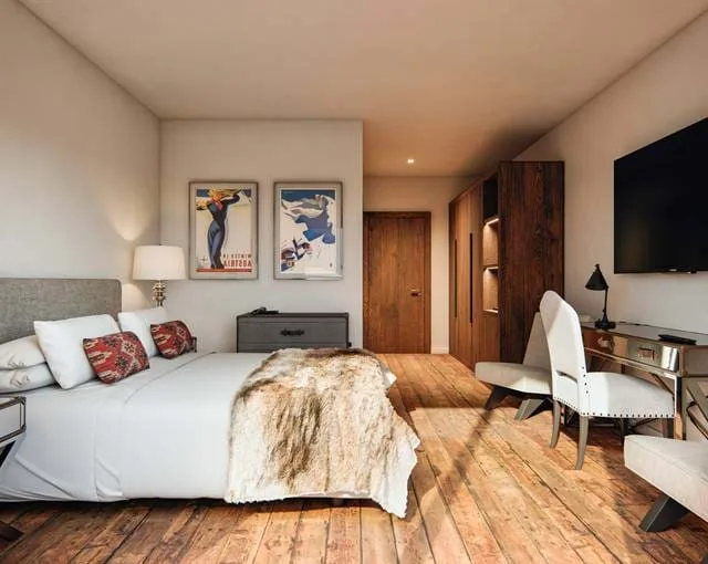 Habitación Premium Maribel con suelos de madera y carteles antiguos de esquí.
