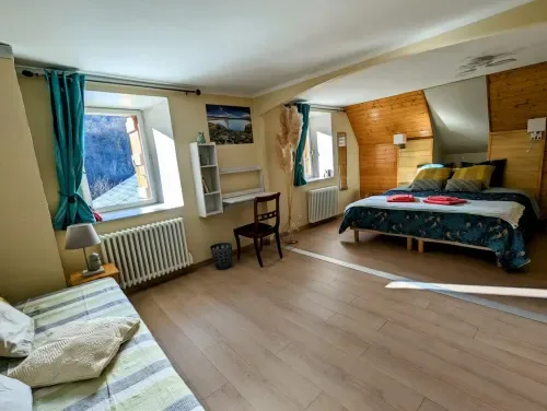 Chambre Printemps with two beds and a desk.