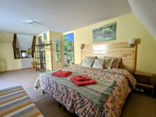 Chambre Été with a wooden bed and bright yellow walls.