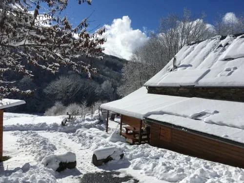 Stone buildings and timber structures in a snowy mountain setting.