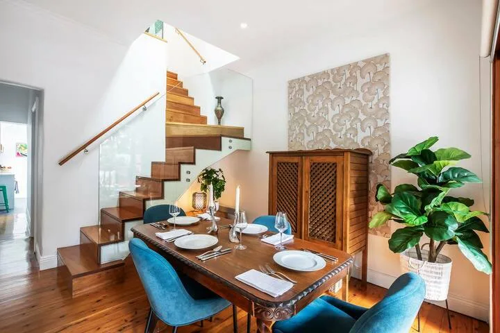 Un comedor con una mesa de madera junto a una escalera.