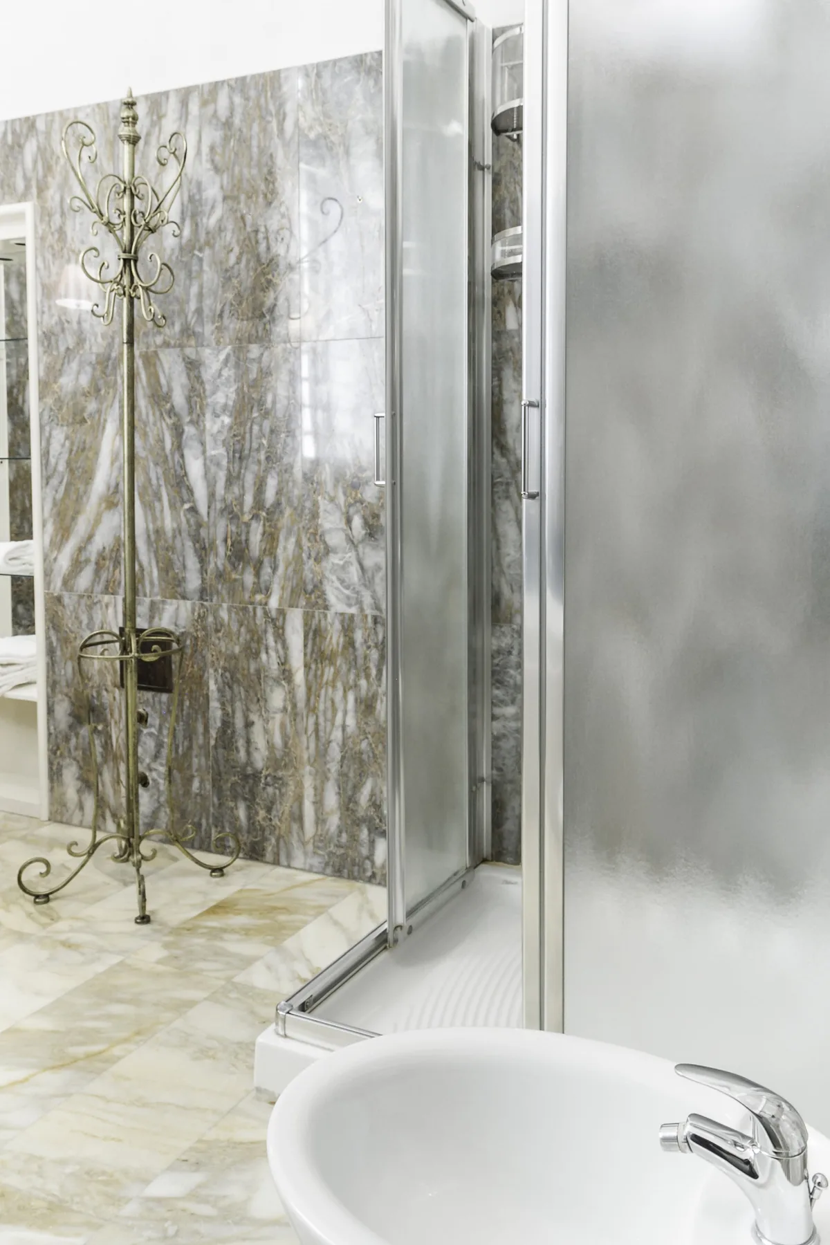 A tiled bathroom with a glass shower and a white sink.