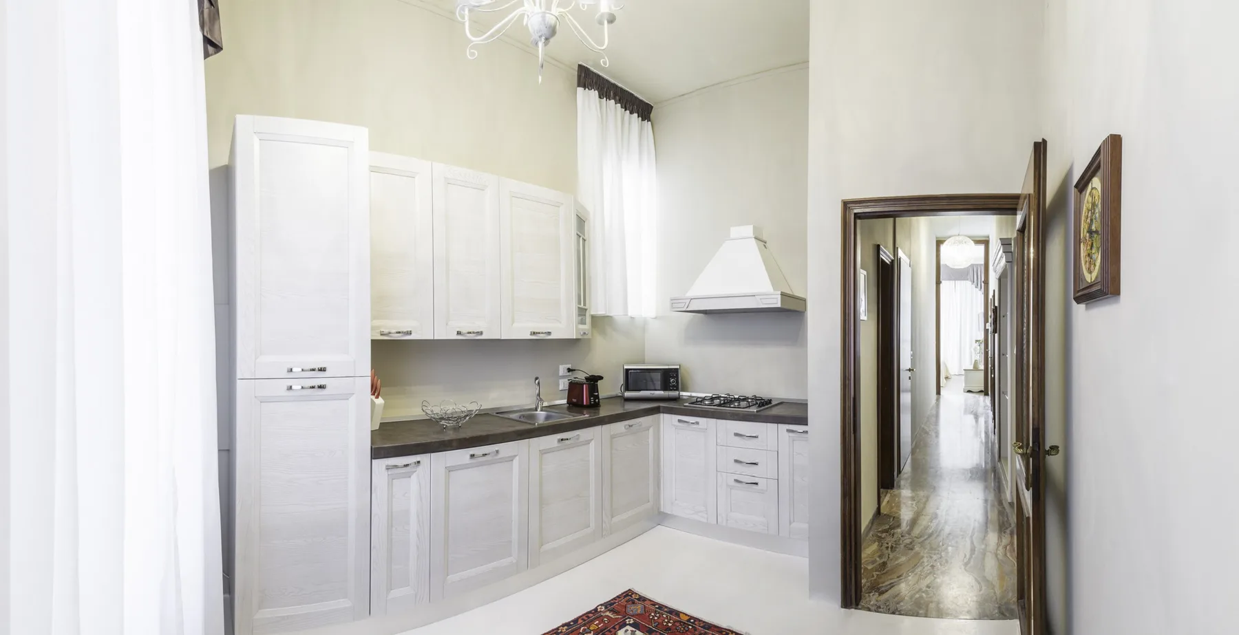 A bright kitchen with white cabinets and a countertop.