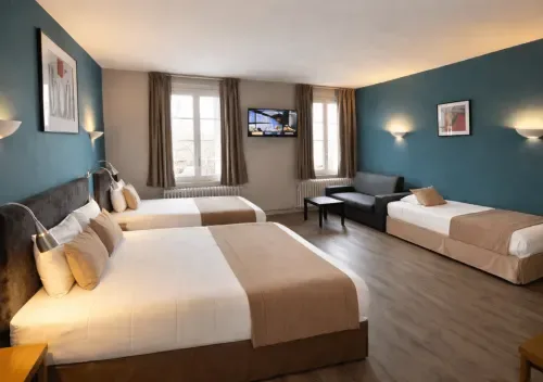 Habitación familiar espaciosa con varias camas, paredes azules, televisión y vistas a la ciudad.