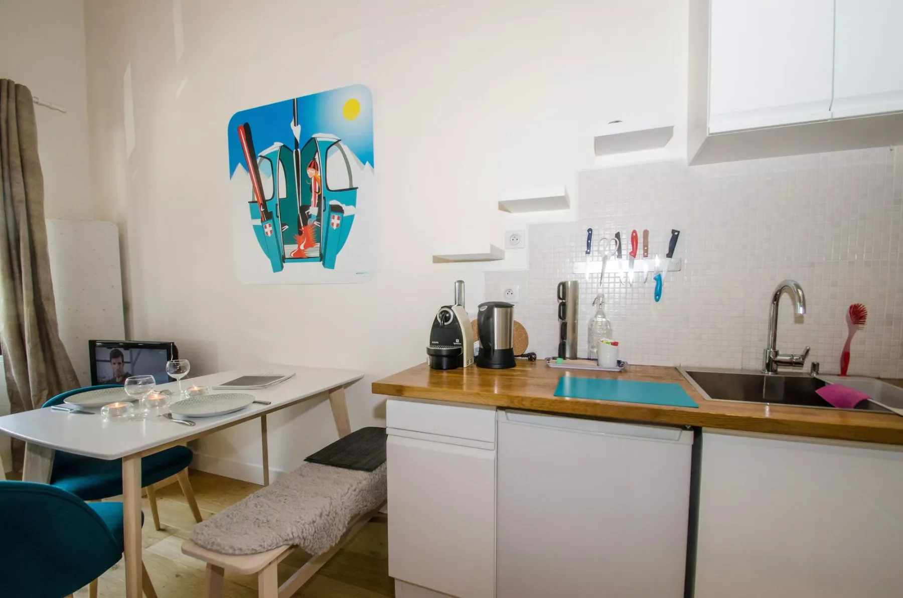 A compact kitchen and dining area with a counter, sink, and small table.