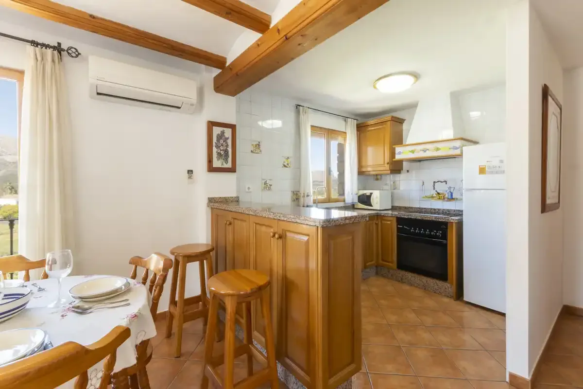A kitchen and dining area with wooden cabinets and a table.