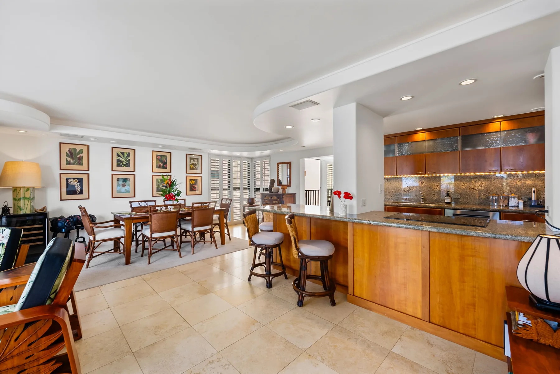 Cocina y comedor de planta abierta con una barra de madera y una mesa de comedor.