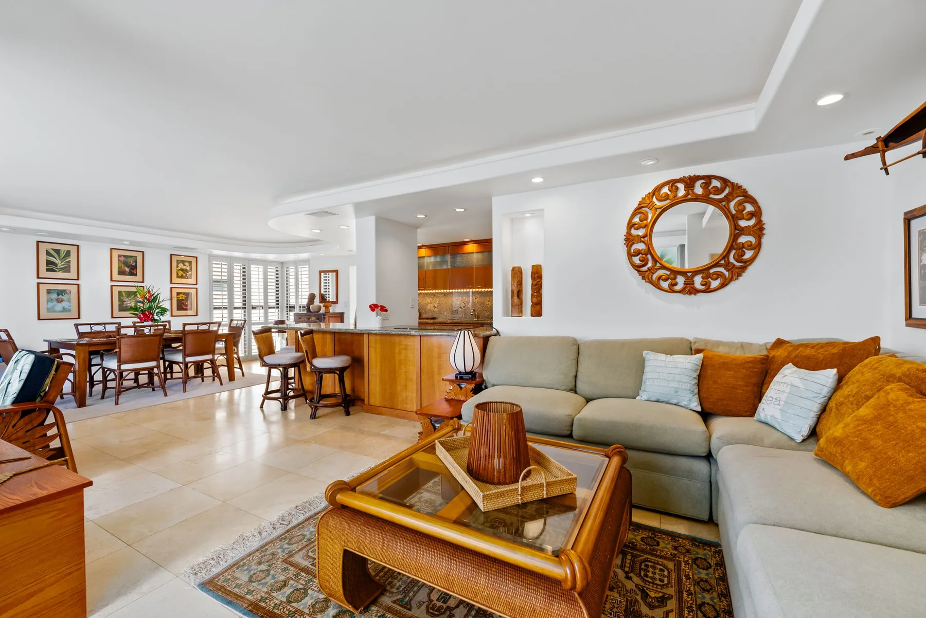 Una luminosa sala-comedor de planta abierta con sofá seccional y mesa de comedor de madera.