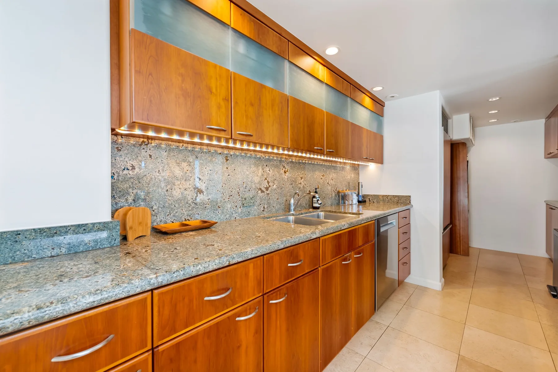 Una cocina con gabinetes de madera, una encimera y un fregadero.