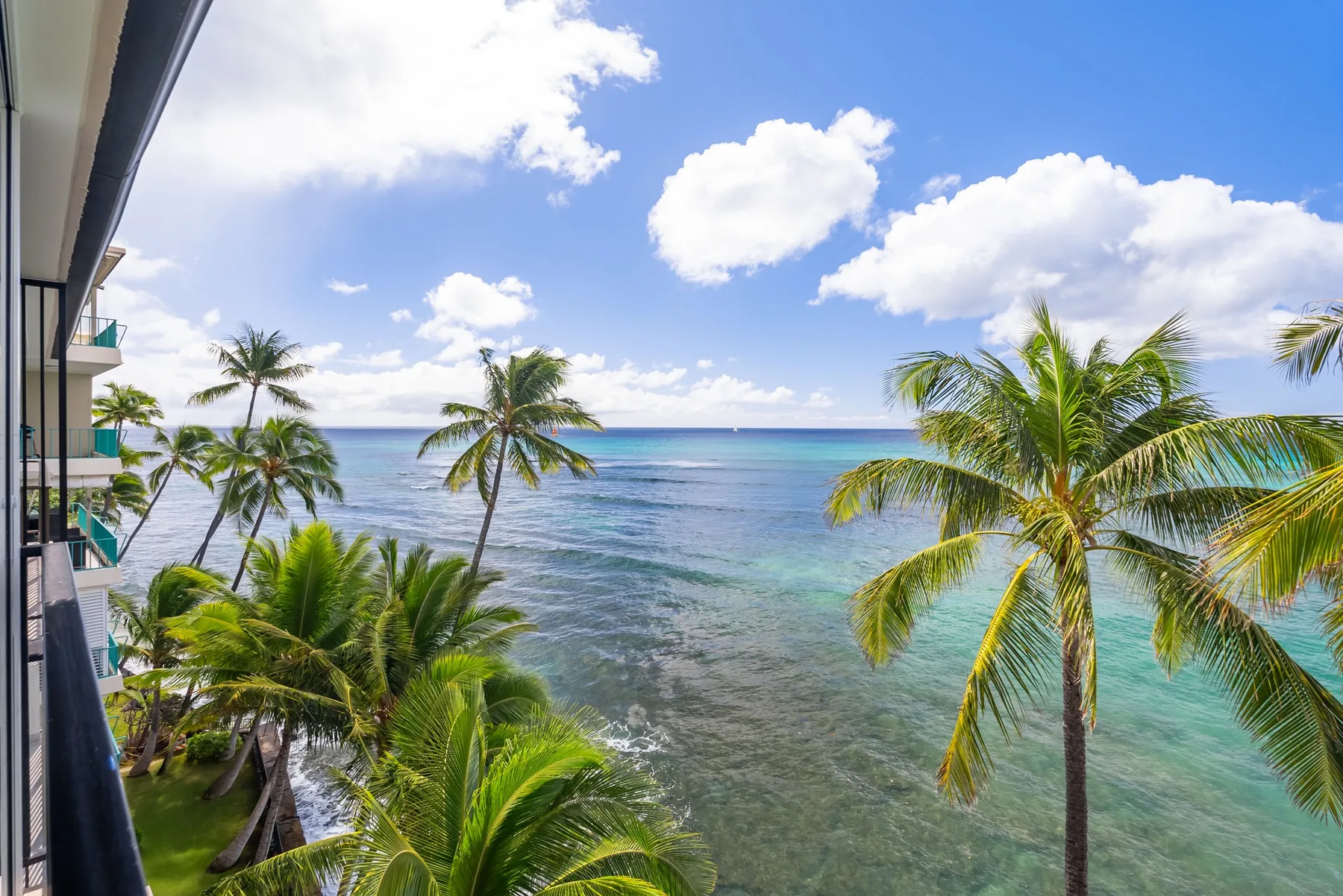 Vista tropical del océano con palmeras a lo largo de la costa.