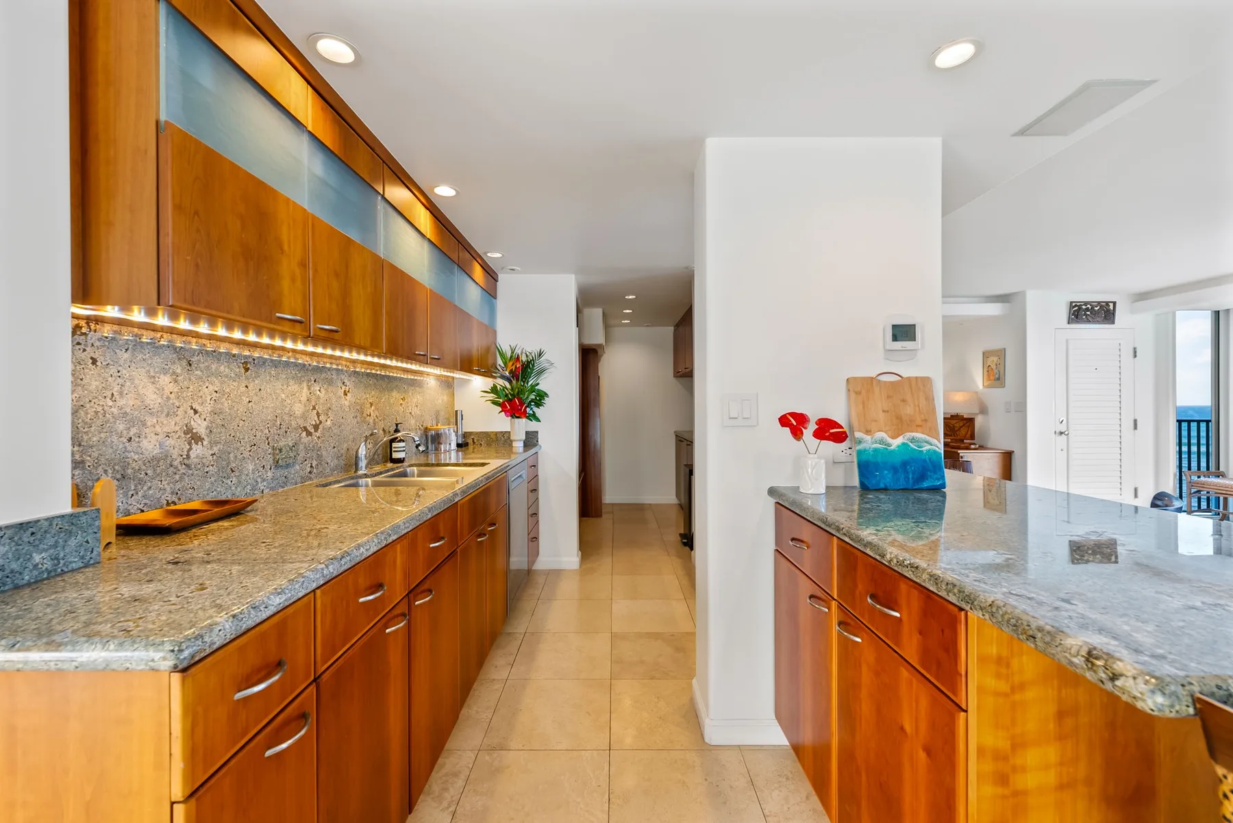 Una cocina luminosa con gabinetes de madera y encimeras de piedra.
