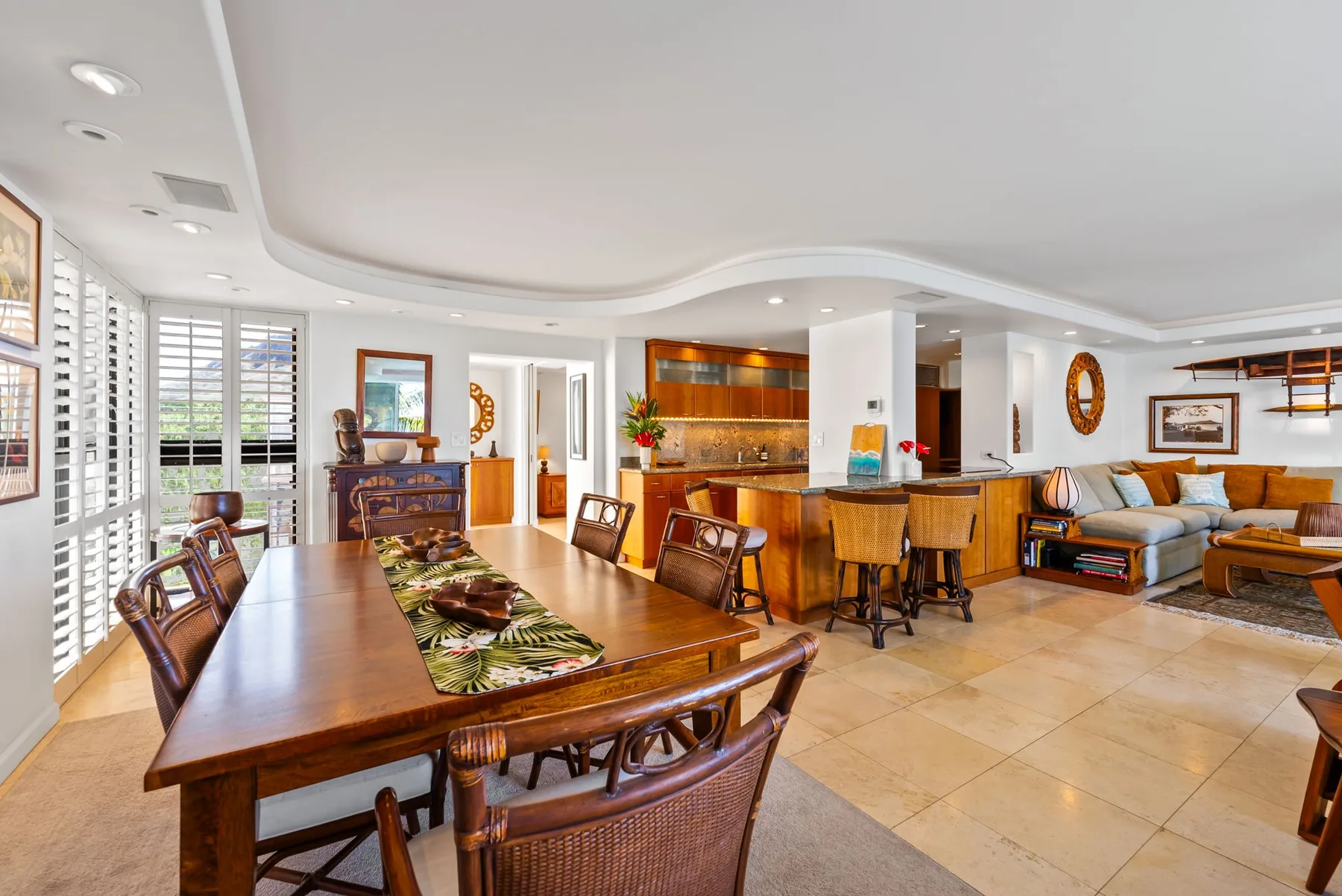Una sala de estar y comedor diáfanos con una mesa de madera y asientos.