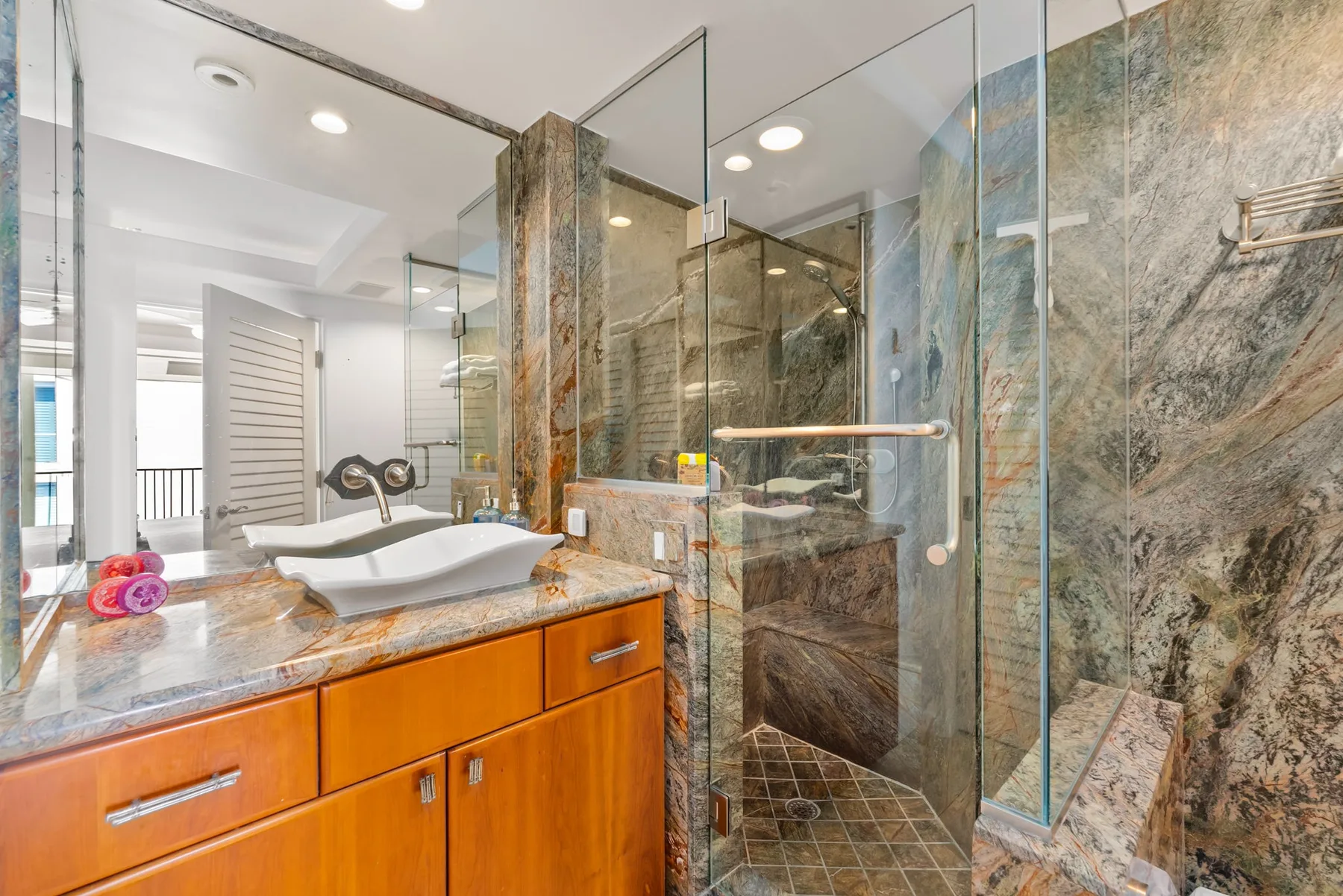 Un mueble de baño con lavabo está junto a una ducha de vidrio.