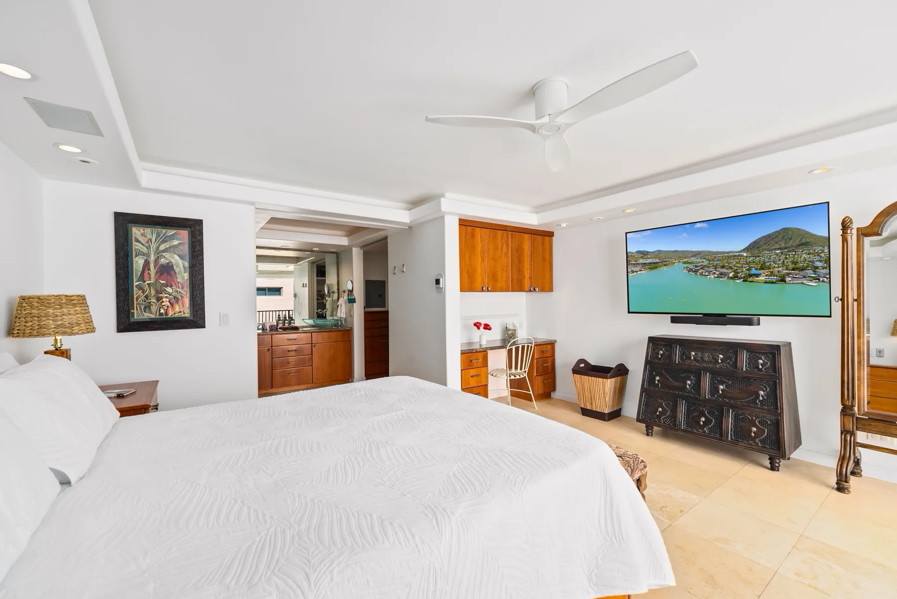 Un dormitorio con una cama grande, un televisor y una cómoda de madera.