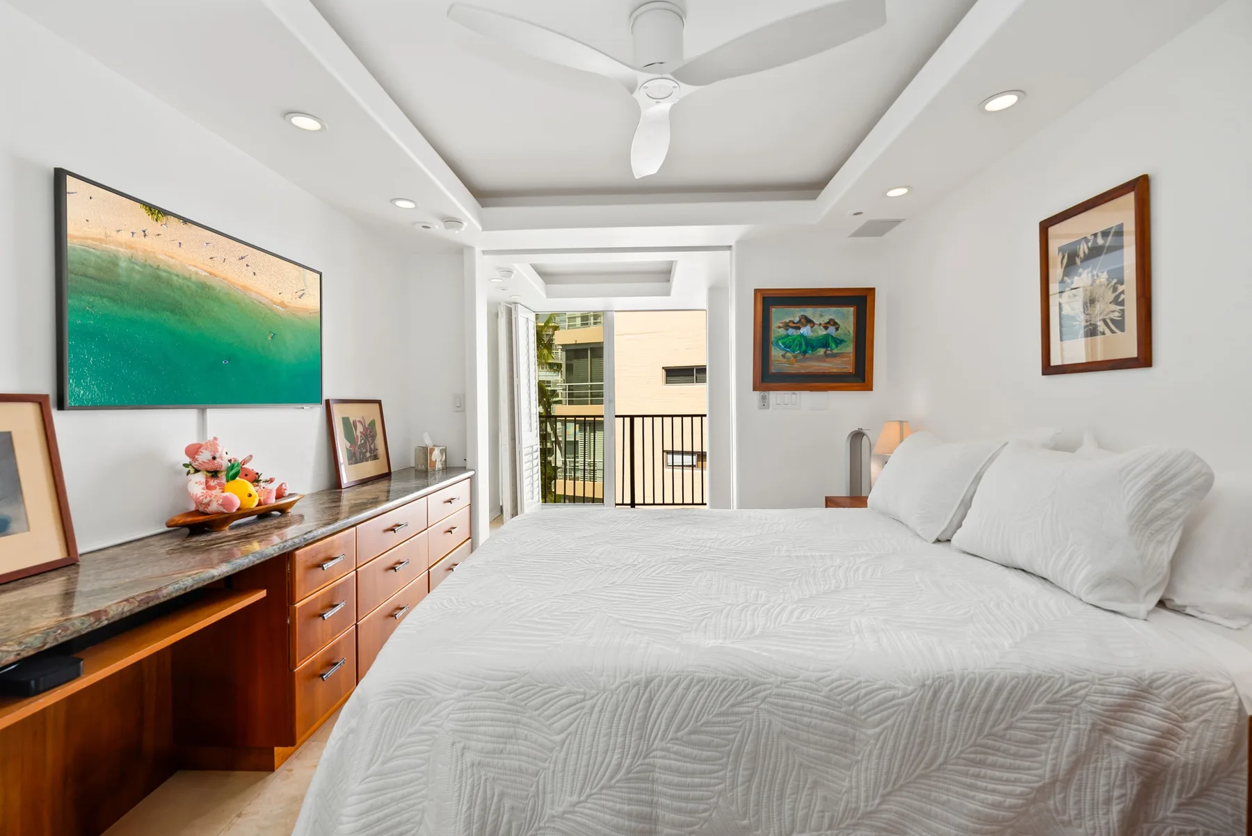 Un dormitorio luminoso con una cama grande y un balcón al fondo.