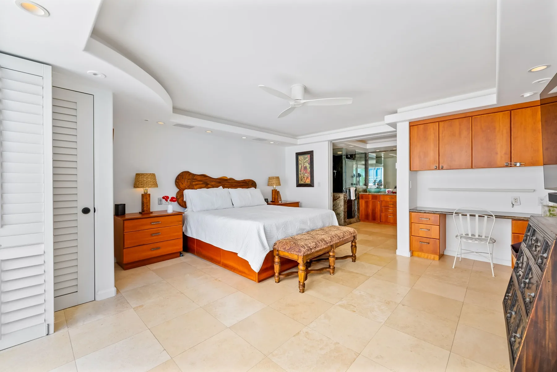 Un dormitorio con una cama, muebles de madera junto a la cama y armarios empotrados.