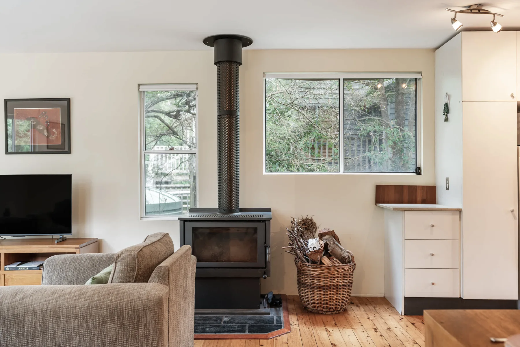 Una sala de estar con asientos, un televisor y una chimenea independiente.