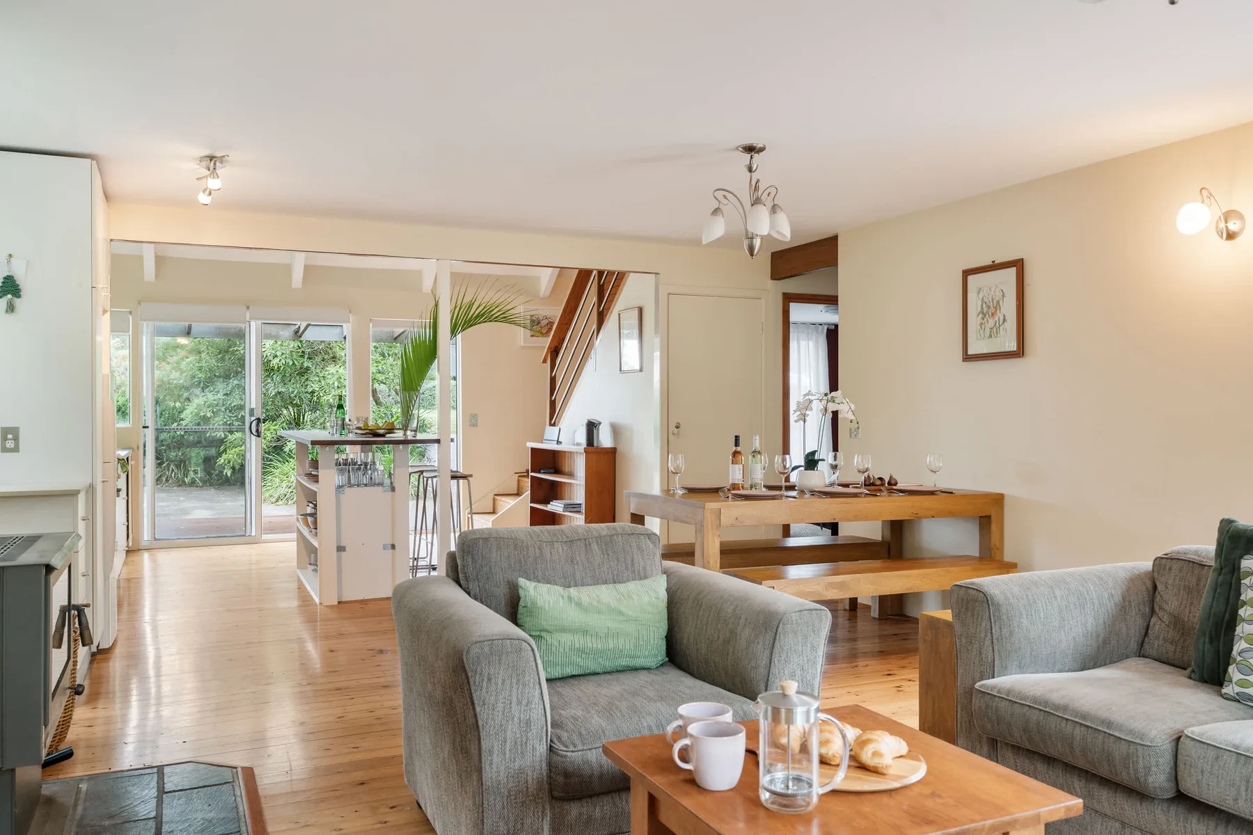 Una sala de estar y comedor diáfana con asientos y una mesa de comedor de madera.
