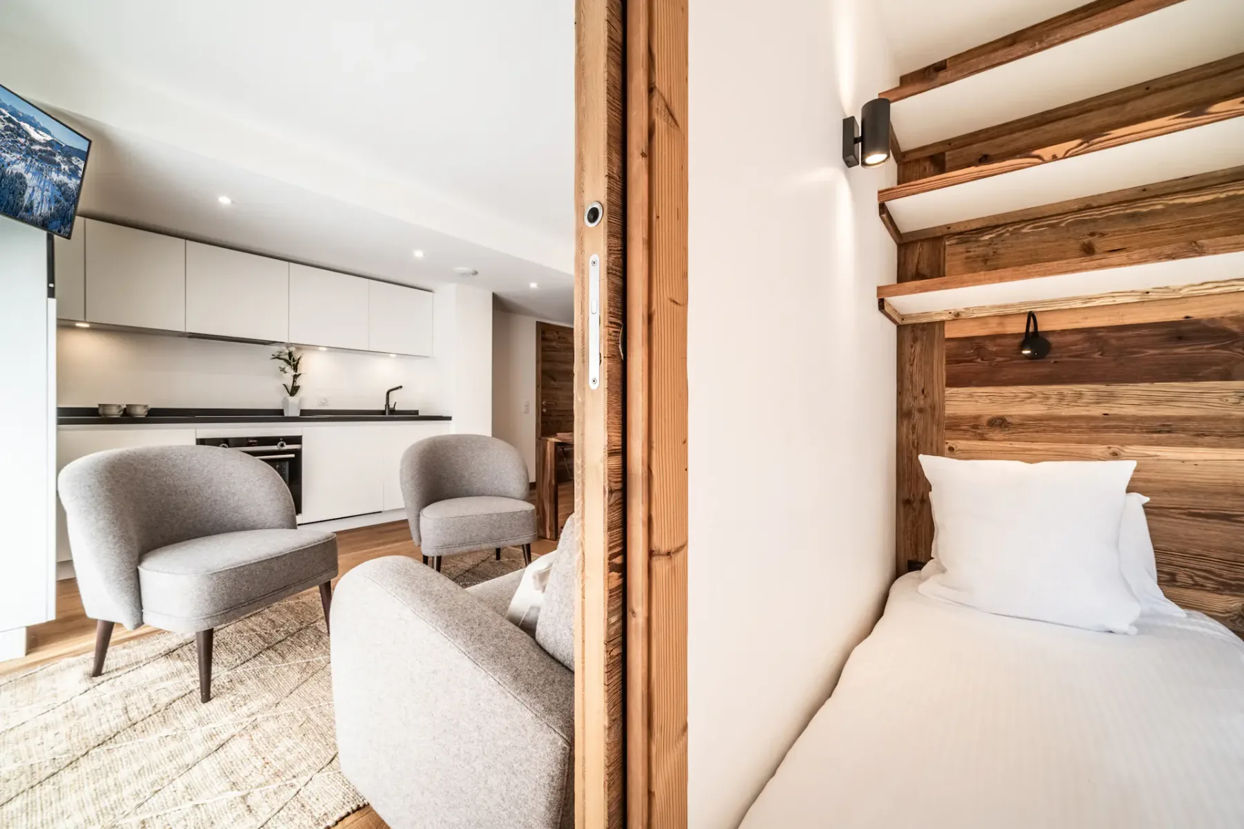 A bedroom with a bed beside a sitting area with upholstered seating.