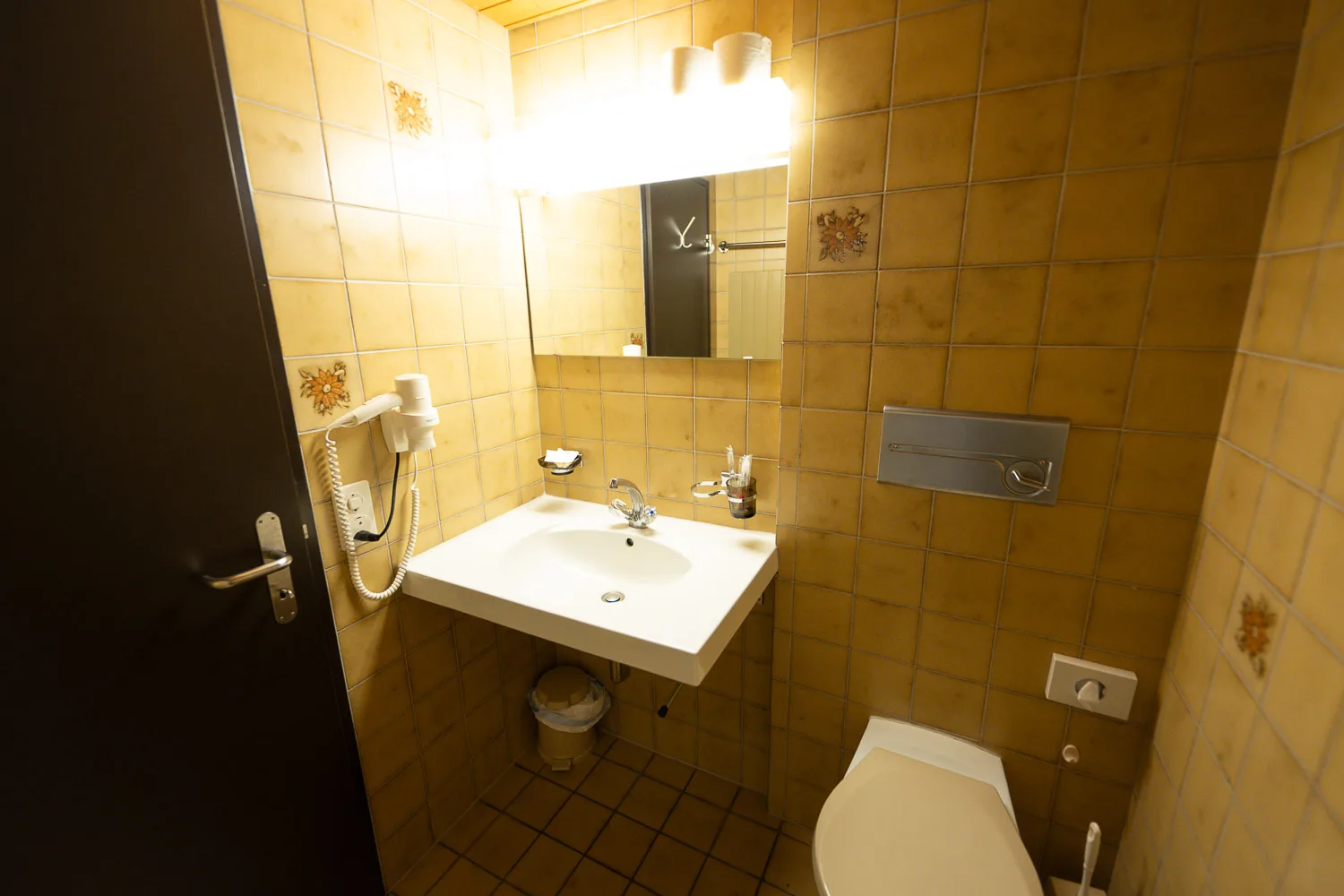 Sink, mirror and hairdryer in a triple room