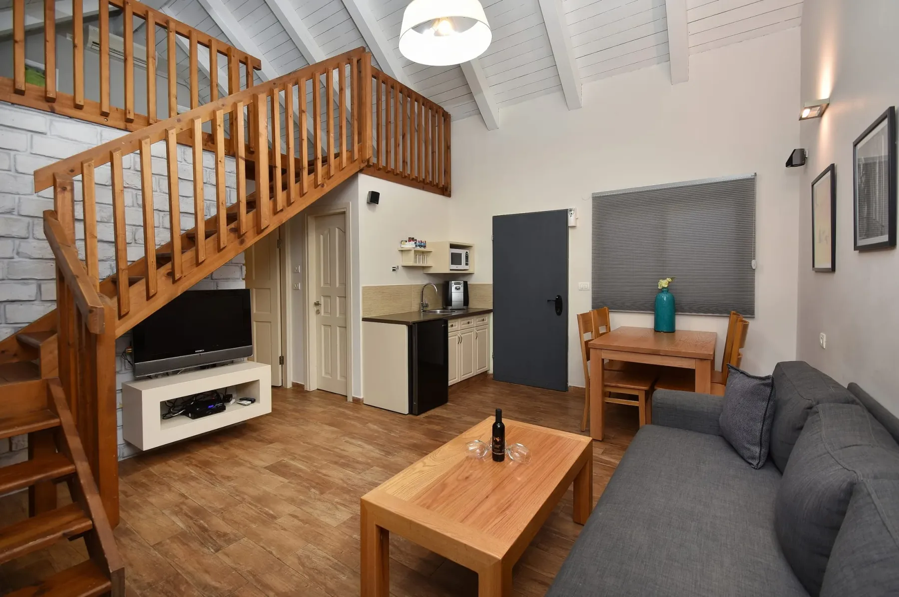 Sala de estar de la suite dúplex familiar y escaleras al altillo abierto con zona para dormir