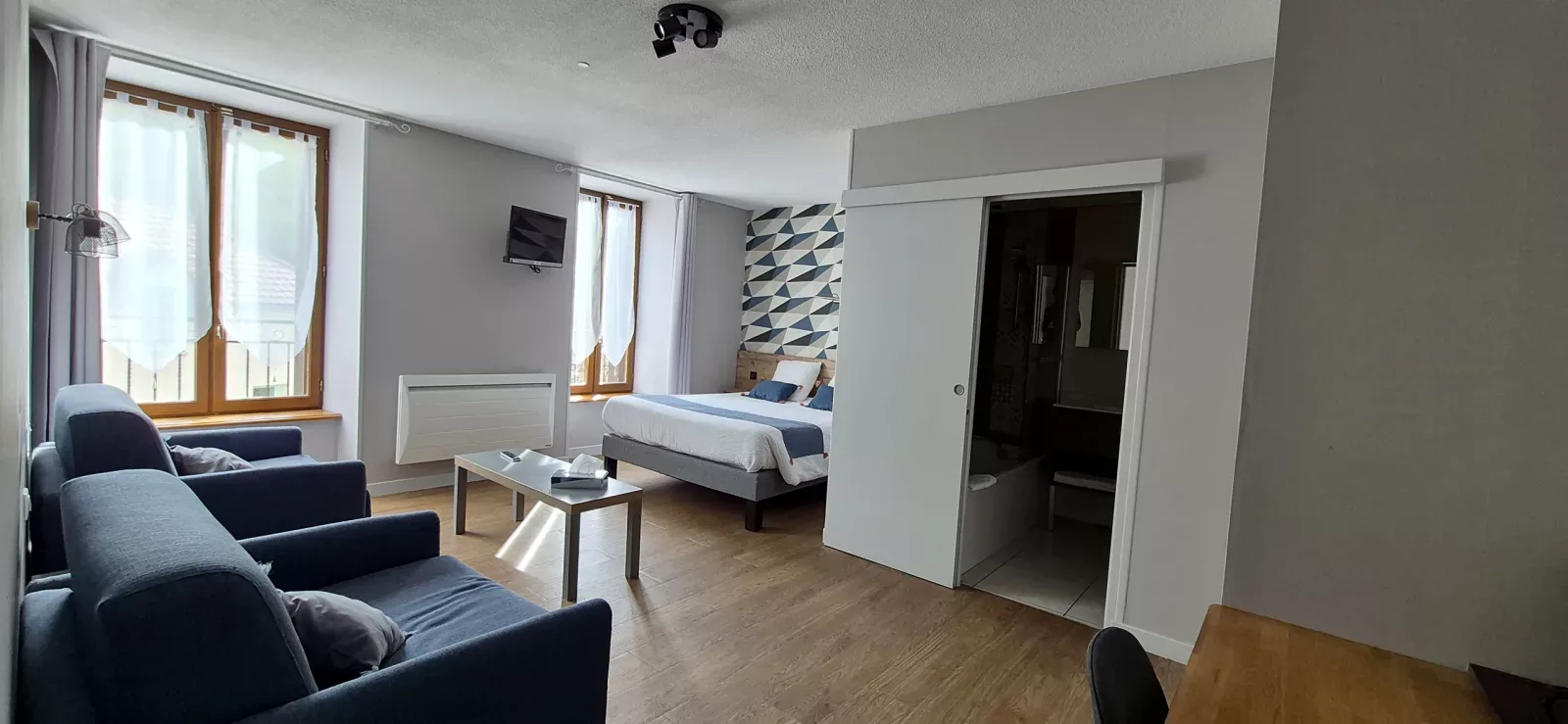 Dormitorio azul amplio con zona de estar