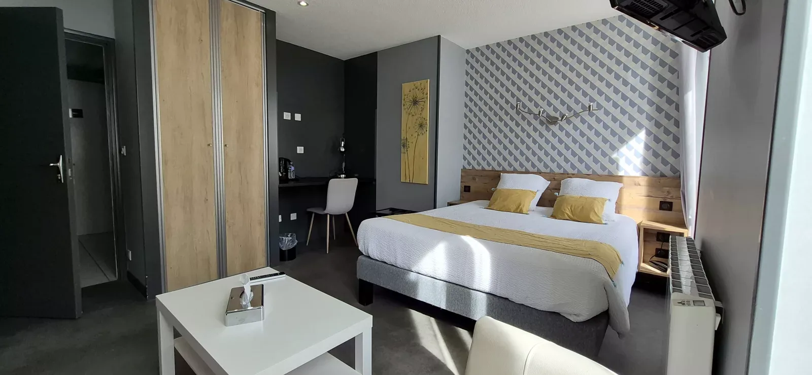 Dormitorio luminoso en gris y amarillo con cama doble y escritorio