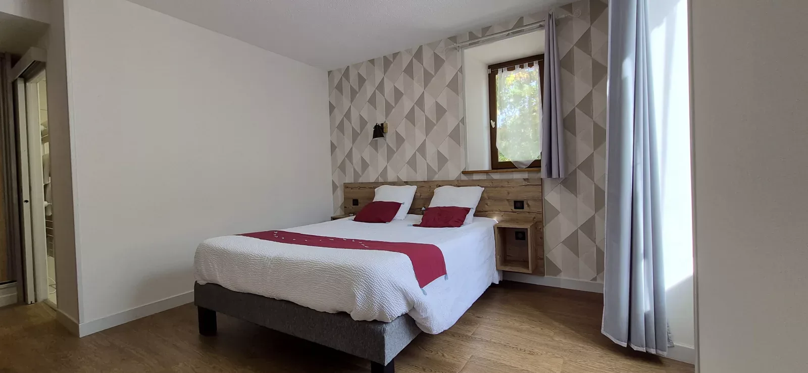 Dormitorio en tonos beige y burdeos con vistas a la vegetación